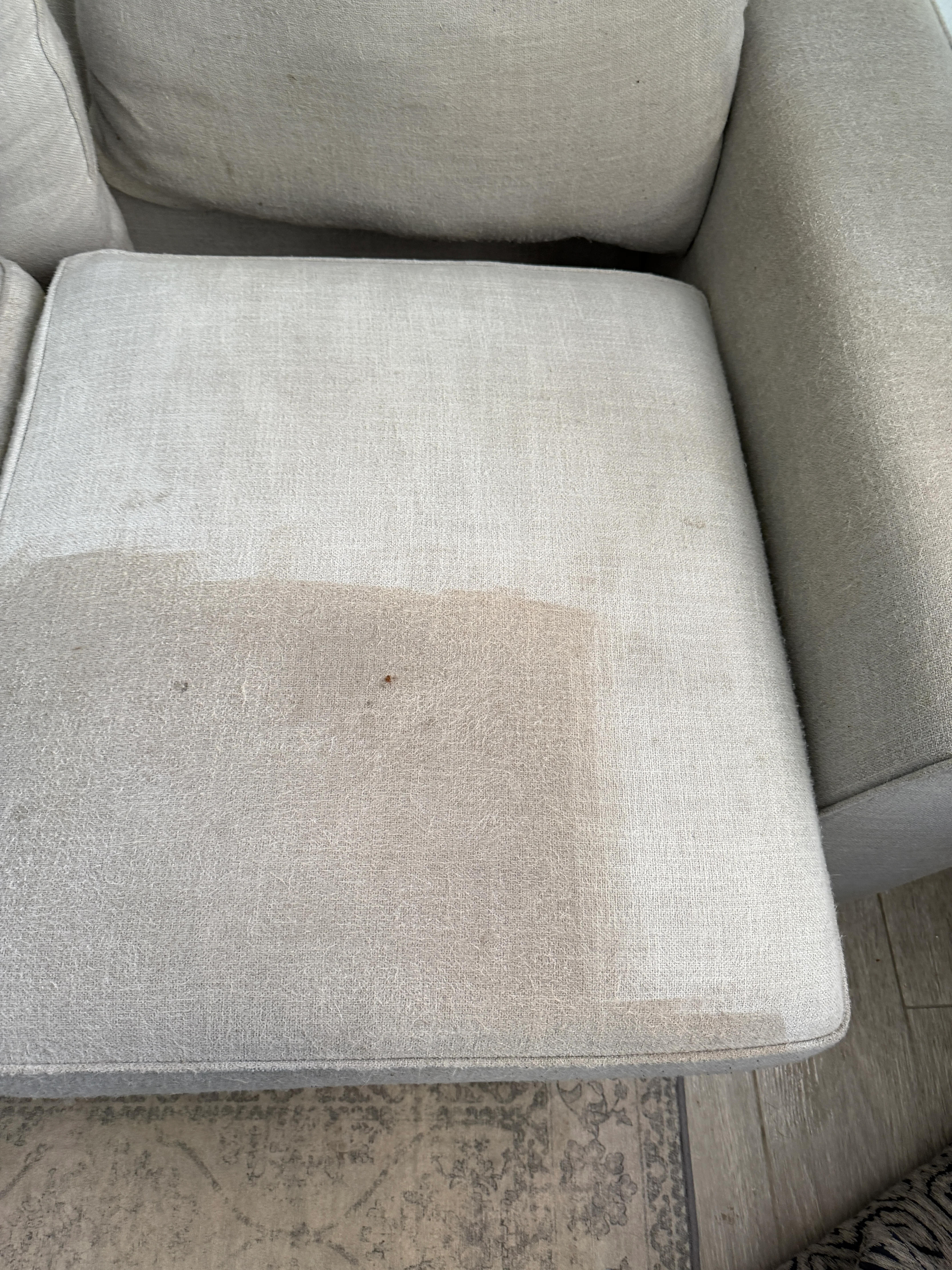 Light beige upholstered chair seat before and after cleaning, showing stain removal results